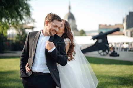 Téléchargez les photos : Happy bride and groom embracing and having fun after wedding ceremony. Loving couple at the street. Stock photo - en image libre de droit
