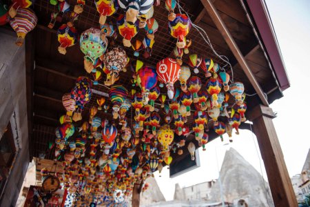 Photo for Different colorful souvenirs of air balloons hanging in street market. Handmade decoration and reminders for travellers in Turkey. Symbolic meaning of Cappadocia. - Royalty Free Image