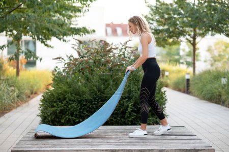 Exercices et concepts sportifs. Vue complète des jeunes femmes se préparant à l'exercice en posant des tapis de yoga dans le parc
