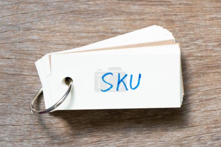 Téléchargez les photos : Carte flash avec écriture manuscrite en mot SKU (Abréviation de l'unité de stockage) sur fond bois - en image libre de droit