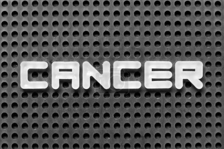 Téléchargez les photos : Lettre alphabet blanc en mot cancer sur fond pegboard noir - en image libre de droit