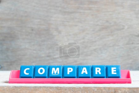 Téléchargez les photos : Lettre alphabet carrelage avec mot comparer en rack de couleur rouge sur fond bois - en image libre de droit