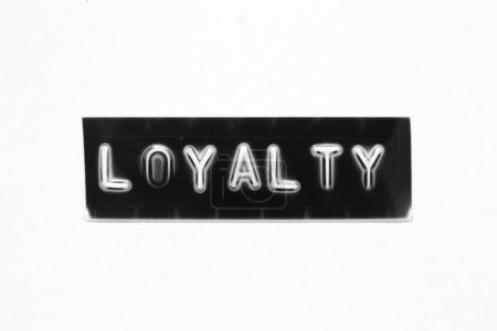 Black color banner that have embossed letter with word loyalty on white paper background