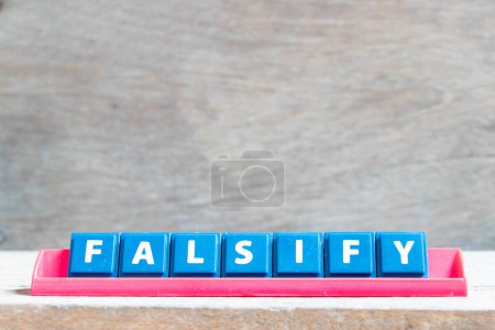 Foto de Tile alphabet letter with word falsify in red color rack on wood background - Imagen libre de derechos
