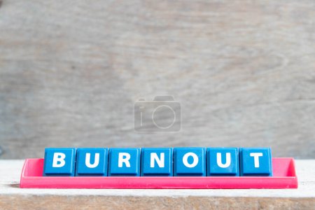 Foto de Tile alphabet letter with word burnout in red color rack on wood background - Imagen libre de derechos