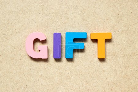 Foto de Color alphabet letter in word gift on wood background - Imagen libre de derechos