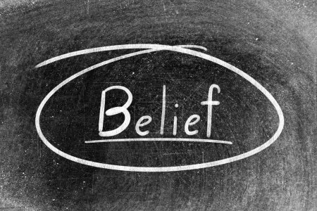 Foto de White chalk hand writing in word belief and circle shape on blackboard background - Imagen libre de derechos