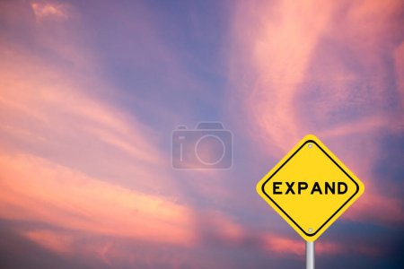 Foto de Signo de transporte amarillo con palabra expandir sobre fondo de cielo de color violeta - Imagen libre de derechos