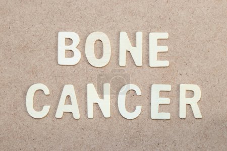 Téléchargez les photos : Wood alphabet letter in word bone cancer on wood background - en image libre de droit