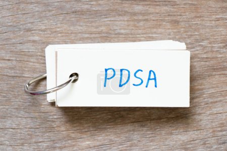 Téléchargez les photos : Carte flash avec écriture en mot PDSA (Abréviation de plan do study act) sur fond de bois - en image libre de droit