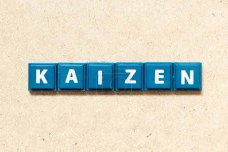 Foto de Letra del alfabeto del azulejo en palabra kaizen sobre fondo de madera - Imagen libre de derechos