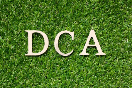 Téléchargez les photos : Lettre alphabet en bois dans le mot DCA (Abréviation de Dollar-coût moyennage) sur fond de gazon vert artificiel - en image libre de droit