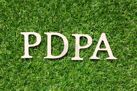 Téléchargez les photos : Lettre alphabet bois dans le mot PDPA (Abréviation de la loi sur la protection des données personnelles) sur fond de gazon vert artificiel - en image libre de droit