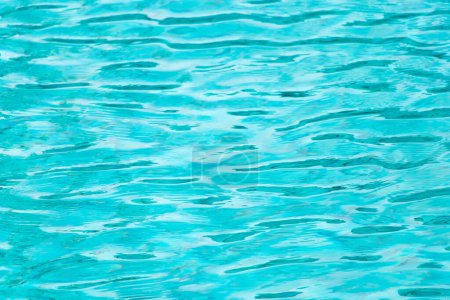 Ripple Water in swimming pool with blue tile floor background