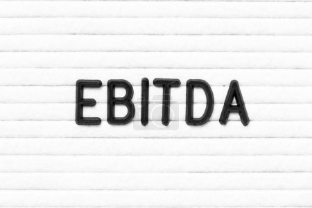 Foto de Color negro letra en palabra EBITDA (abreviatura de ganancias antes de intereses, impuestos, depreciación y amortización) sobre fondo de pizarra de fieltro blanco - Imagen libre de derechos