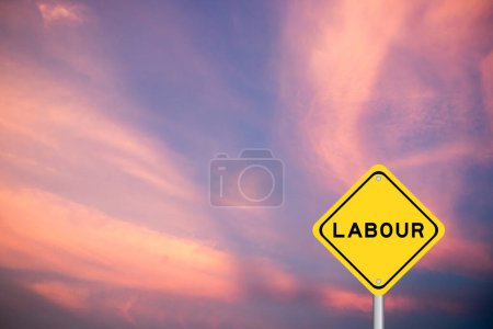 Foto de Signo de transporte amarillo con palabra trabajo sobre fondo de cielo de color violeta - Imagen libre de derechos