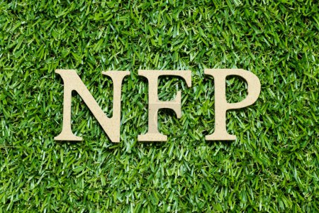 Téléchargez les photos : Lettre alphabet en bois dans le mot NFP (Abréviation des feuilles de paie non agricoles) sur fond d'herbe verte - en image libre de droit
