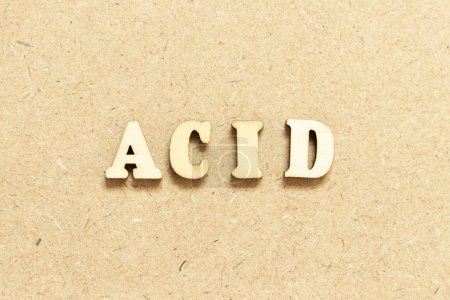 Foto de Letra del alfabeto en ácido de palabra sobre fondo de madera - Imagen libre de derechos