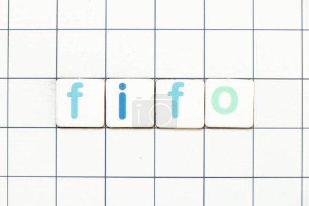 Téléchargez les photos : Lettre de tuiles colorées dans le mot FIFO (Abréviation du premier entré premier sorti) sur fond de grille blanche - en image libre de droit