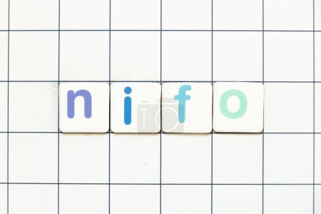 Téléchargez les photos : Carrelage coloré lettre dans le mot NIFO (abréviation de la prochaine dans le premier sorti) sur fond de grille blanche - en image libre de droit