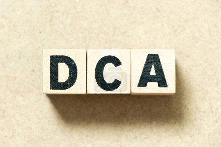 Photo for Alphabet letter block in word DCA (Abbreviation of Dollar-cost averaging) on wood background - Royalty Free Image