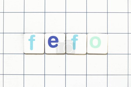 Téléchargez les photos : Carrelage coloré lettre en mot FEFO (Abréviation du premier arrivé à expiration premier sorti) sur fond de grille blanche - en image libre de droit