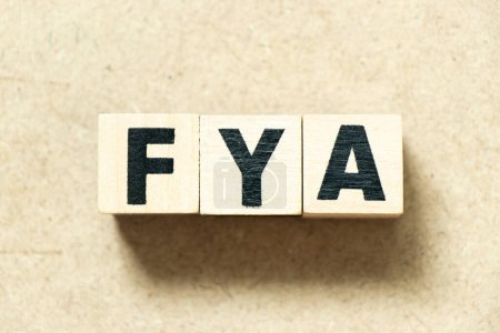 Foto de Alfabeto letra bloque en la palabra FYA (Abreviatura de Para su acción o atención) sobre fondo de madera - Imagen libre de derechos