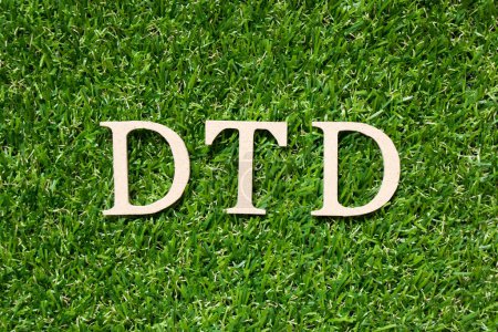 Foto de Letra del alfabeto de madera en la palabra DTD (Abreviatura de puerta a puerta, definición del tipo de documento, declaración de transacción del depositante) sobre fondo de hierba verde artificial - Imagen libre de derechos