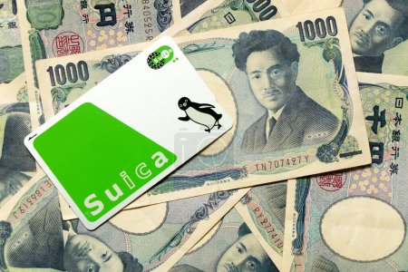 Foto de Bangkok, Tailandia - 12 / 08 / 2023: Tarjeta Suica sobre fondo japonés de billetes de 1000 yenes - Imagen libre de derechos