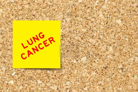 Téléchargez les photos : Papier de note jaune avec mot cancer du poumon sur fond de carton de liège avec espace de copie - en image libre de droit