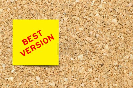 Yellow note paper with word best version on cork board background with copy space
