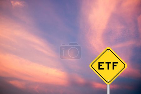 Yellow transportation sign with word ETF (abbreviation of Exchange Traded Fund) on violet color sky background