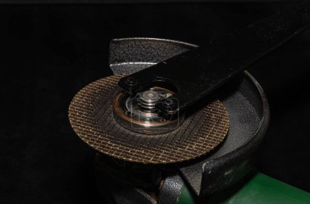 Photo for Master installs a disc on an angle grinder - Royalty Free Image