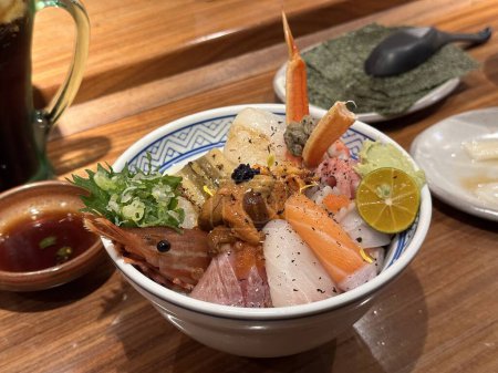 Téléchargez les photos : Fruits de mer crus frais bol de riz mélangé. Kaisen-Don. Riz japonais avec sashimi de crevettes, thon, Otoro, saumon, oursin, Engawa et autres poissons. Vue du dessus. - en image libre de droit