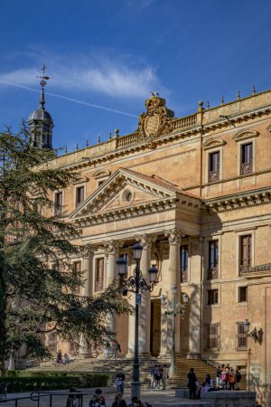 Téléchargez les photos : Salamanque, Espagne - 20 mars 2023 : Entrée de la Faculté de philologie, étudiants rassemblés autour, cigognes assises sur le dessus - en image libre de droit
