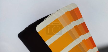 Pantone Color Matching System. Orangefarbene Palette auf weißem Hintergrund. Farbwiedergabesystem, ein Ventilator mit Schattierungen oranger Farben auf weißem Hintergrund.