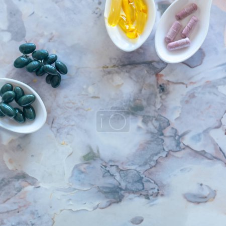 Foto de Medicina o vitamina en cucharas blancas sobre una mesa limpia Copiar el fondo del espacio - Imagen libre de derechos