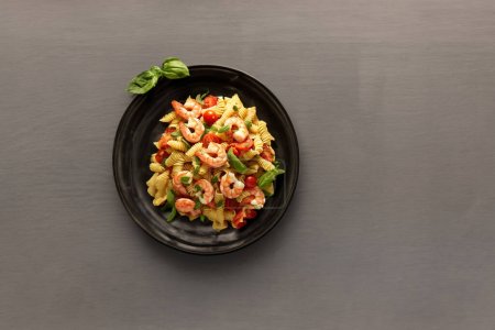 Téléchargez les photos : Une assiette vidée d'une délicieuse salade de pâtes aux crevettes - en image libre de droit
