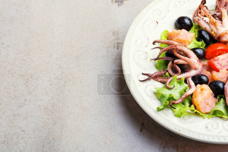 Foto de Ensalada fresca y colorida cubierta con tiernos anillos de calamares - Imagen libre de derechos