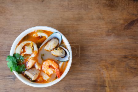 Photo for Hearty bouillabaisse seafood soup with bread on wooden table - Royalty Free Image