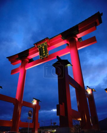 Téléchargez les photos : Un énorme Torii, porte d'entrée rouge du sanctuaire shinto, au Japon au crépuscule - en image libre de droit