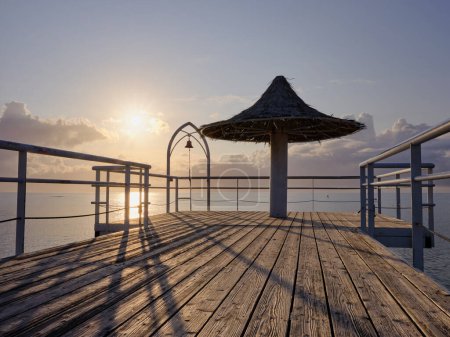 Téléchargez les photos : Coucher de soleil et jetée en bois dans la mer - en image libre de droit