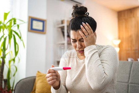 Téléchargez les photos : Femme se sentant inquiète après avoir fait un test de grossesse. - en image libre de droit