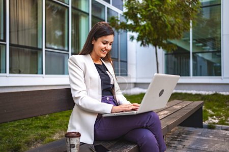 Photo for Businesswoman working on laptop outdoors. - Royalty Free Image