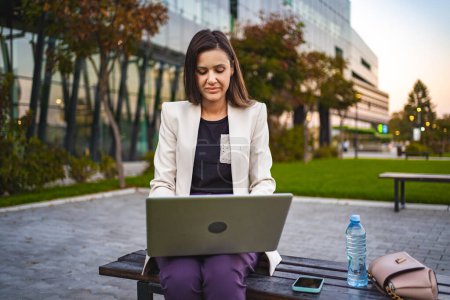 Téléchargez les photos : Femme d'affaires travaillant sur ordinateur portable à l'extérieur. - en image libre de droit