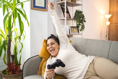 Foto de Mujer divirtiéndose jugando videojuegos en casa. - Imagen libre de derechos