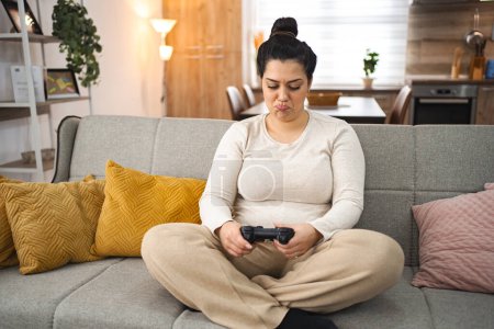 Photo for Competitive woman playing video game at home. - Royalty Free Image
