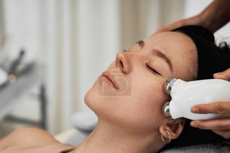 Massage du visage féminin avec des gadgets. Photo de haute qualité