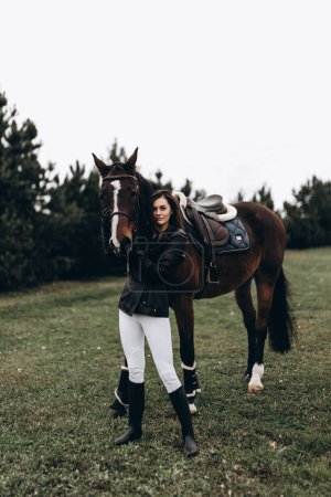 Photo for A young equestrian in uniform poses with a beautiful, majestic horse. High quality photo - Royalty Free Image