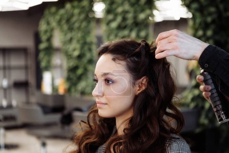 Téléchargez les photos : Le maître fait de la coiffure dans un salon de beauté. Une jeune femme se prépare pour un rendez-vous. Photo de haute qualité - en image libre de droit